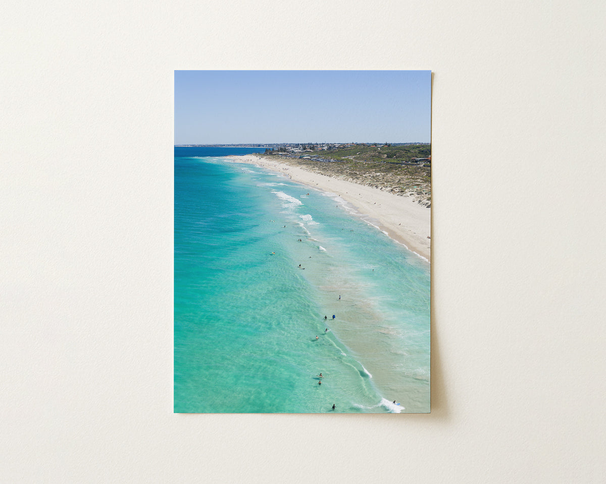 Fine art paper print of aerial photography of Trigg Beach, a long curving beach with turquoise water, white sand and coastal bush in portrait orientation