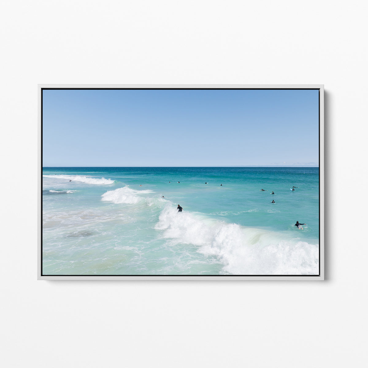 White framed canvas print of aerial photography of Scarborough Beach, a surfer riding a breaking wave with white foam in turquoise water