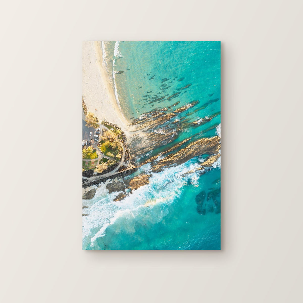 Stretched canvas print of aerial photography of Snapper Rocks, rock ridges, white foam and turquoise water beside a walkway in portrait orientation on a wall