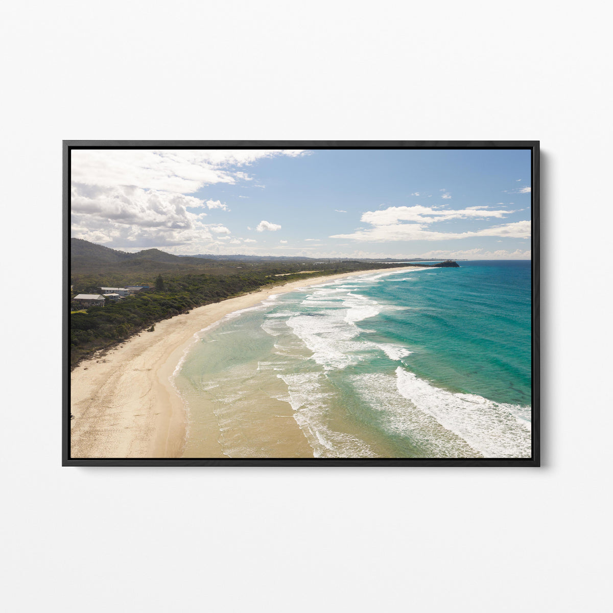Aerial photograph of surf peeling along the length of Hastings Point beach NSW in a black frame