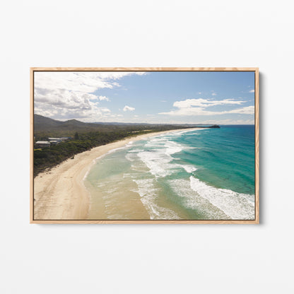 Aerial photograph of surf peeling along the length of Hastings Point beach NSW in an oak frame