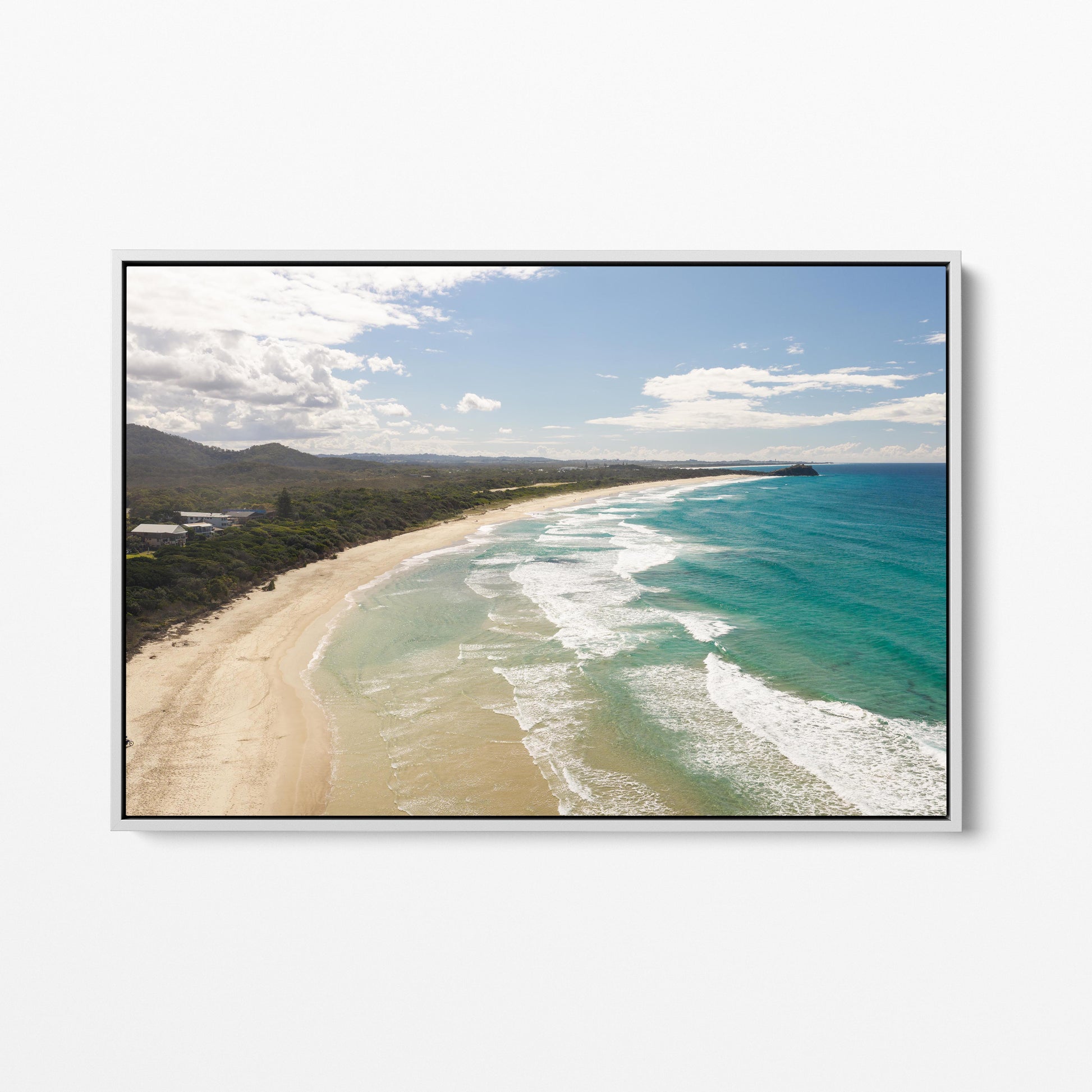 Aerial photograph of surf peeling along the length of Hastings Point beach NSW in a white frame