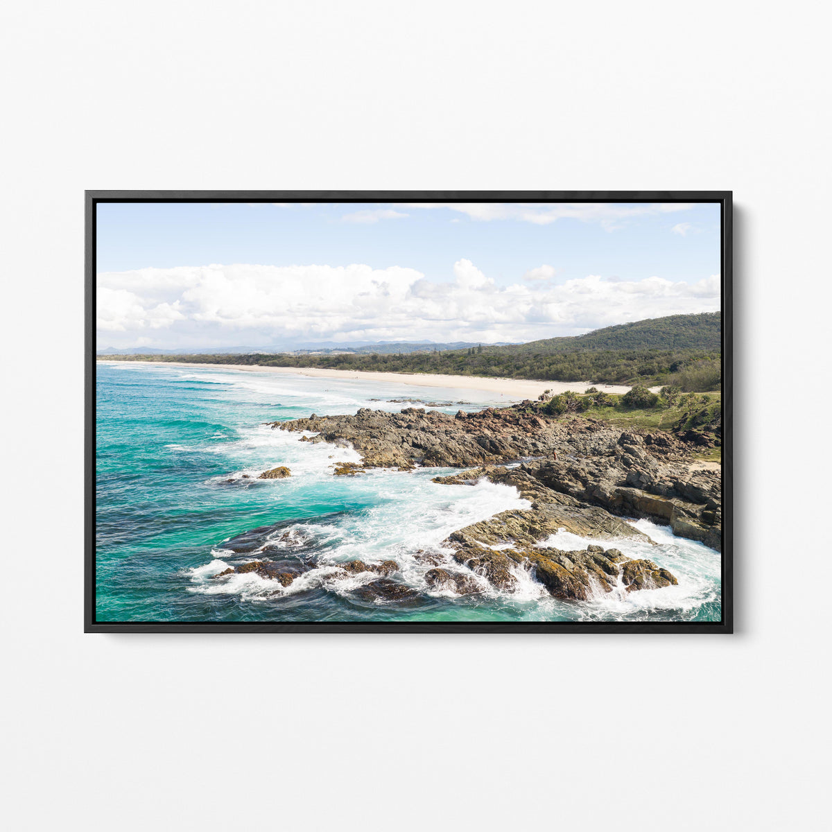 Aerial photograph of surf breaking over the headland rocks at Hastings Point NSW in a black frame
