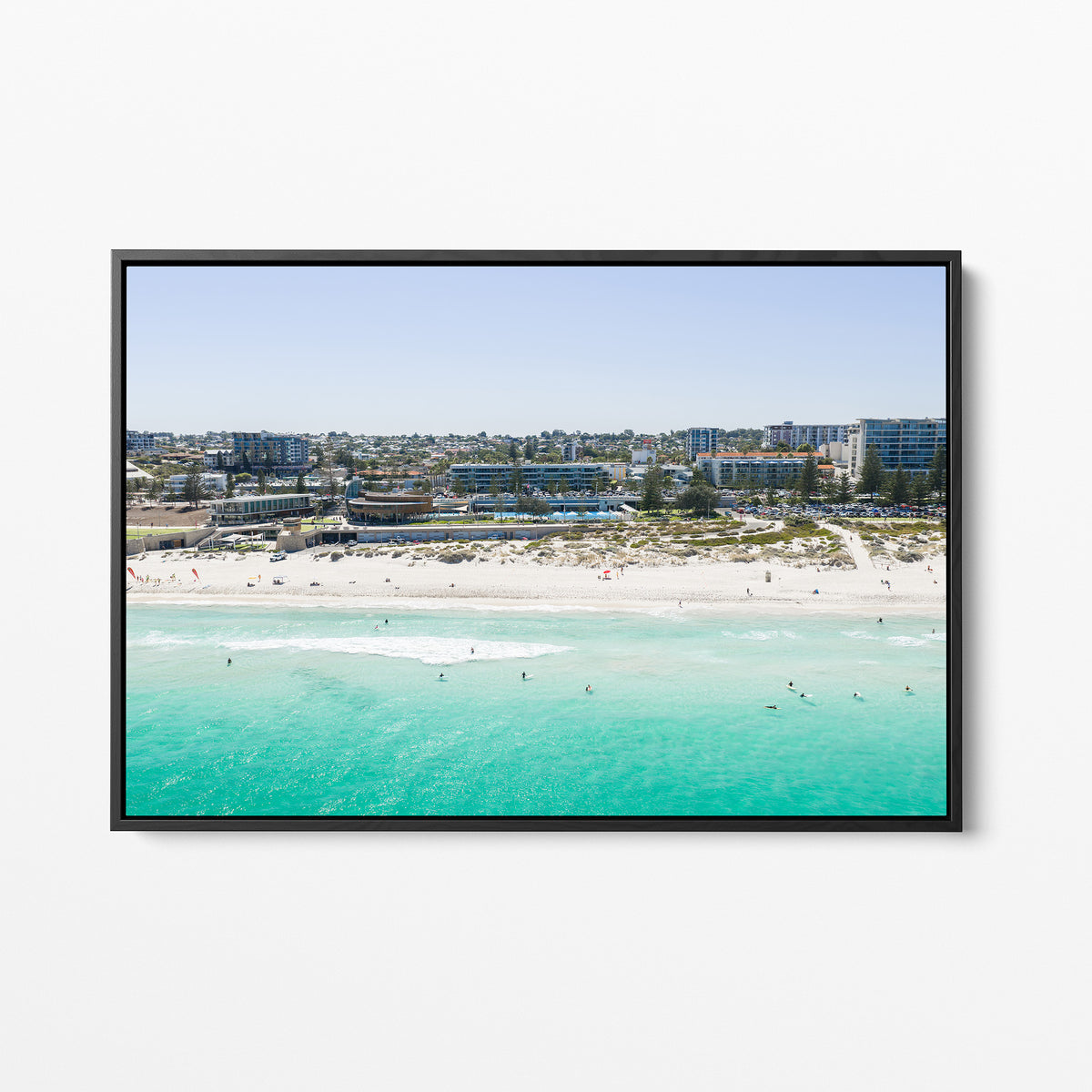 Black framed canvas print of aerial photography of Scarborough Beach, buildings along the beachfront above turquoise shallows and white sand