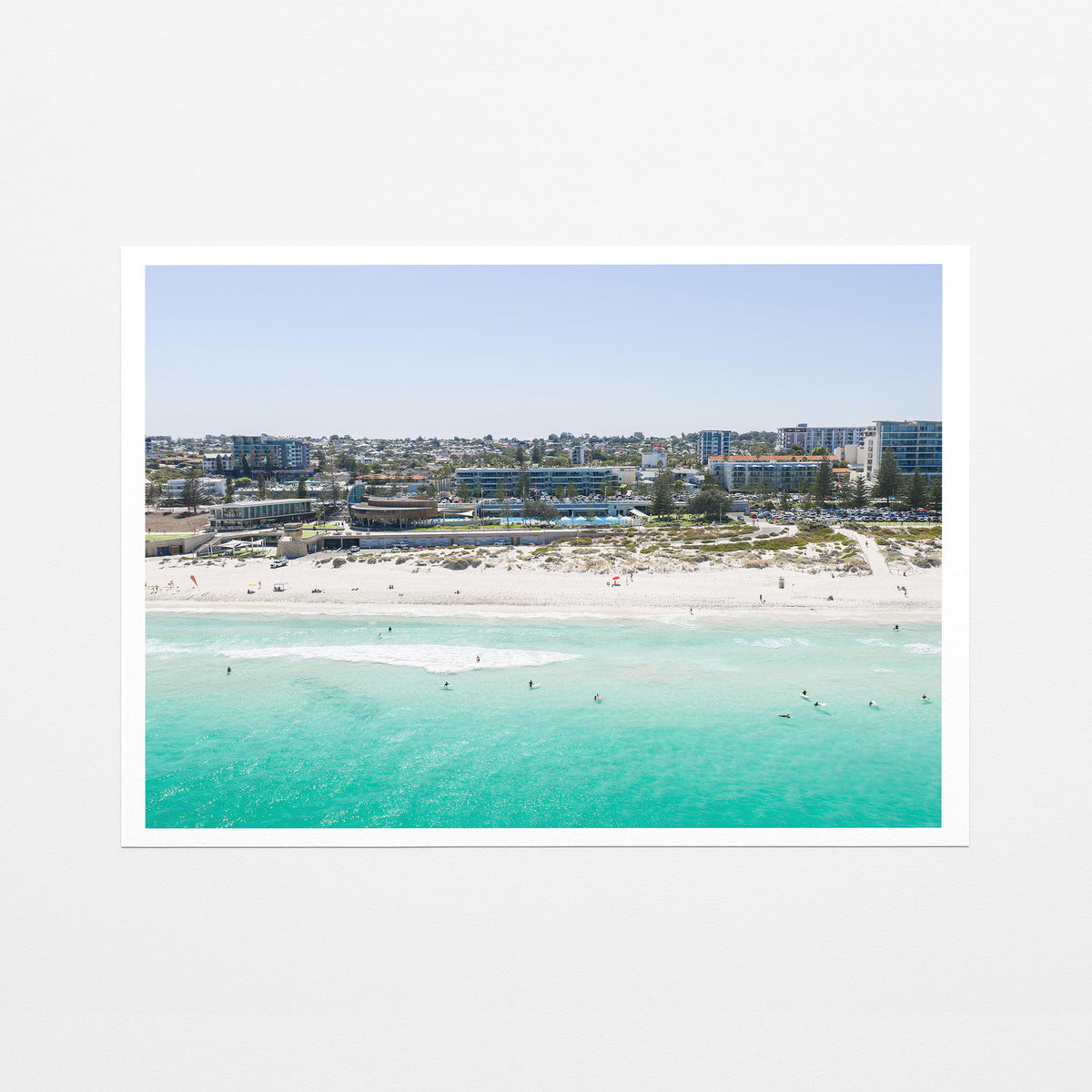 Fine art paper print of aerial photography of Scarborough Beach, buildings along the beachfront above turquoise shallows and white sand with a white border