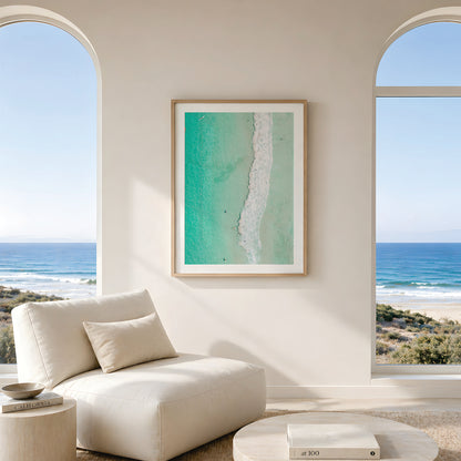 Framed canvas print of aerial photography of Scarborough Beach, a line of white wave across green turquoise shallows in portrait orientation hanging in a living room