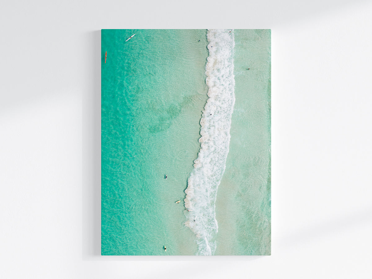 Stretched canvas print of aerial photography of Scarborough Beach, a line of white wave across green turquoise shallows in portrait orientation on a wall