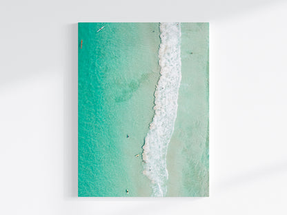 Stretched canvas print of aerial photography of Scarborough Beach, a line of white wave across green turquoise shallows in portrait orientation on a wall