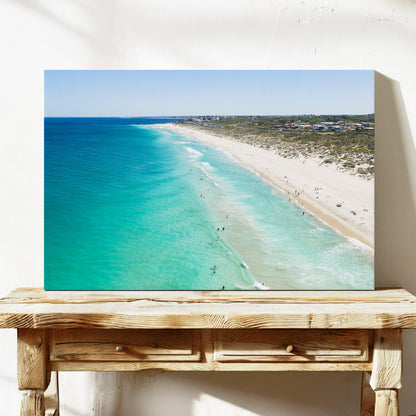 Stretched canvas print of aerial photography of Trigg Beach, a long curving beach with turquoise water, white sand and coastal bush on a console table
