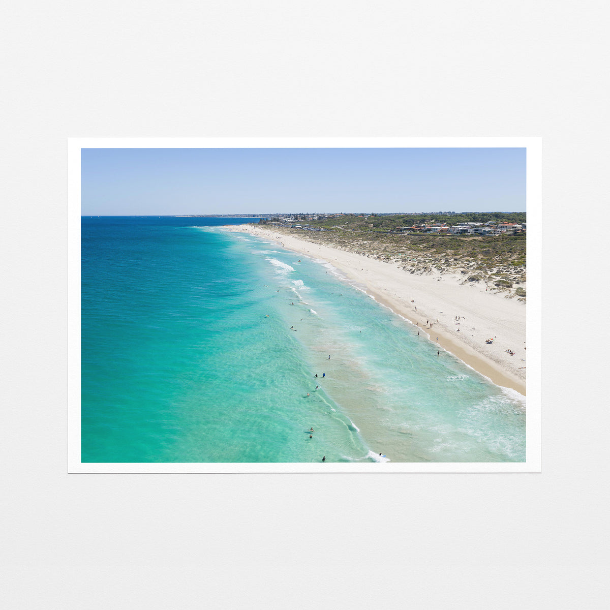 Fine art paper print of aerial photography of Trigg Beach, a long curving beach with turquoise water, white sand and coastal bush with a white border