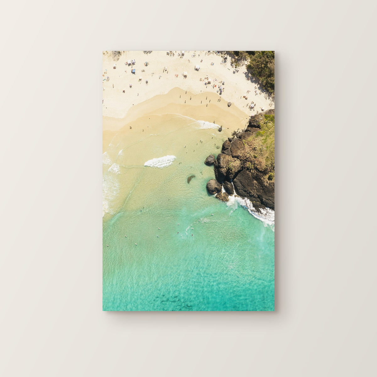 Stretched canvas print of aerial photography of Dreamtime Beach, headland rocks above golden sand and turquoise water in portrait orientation on a wall