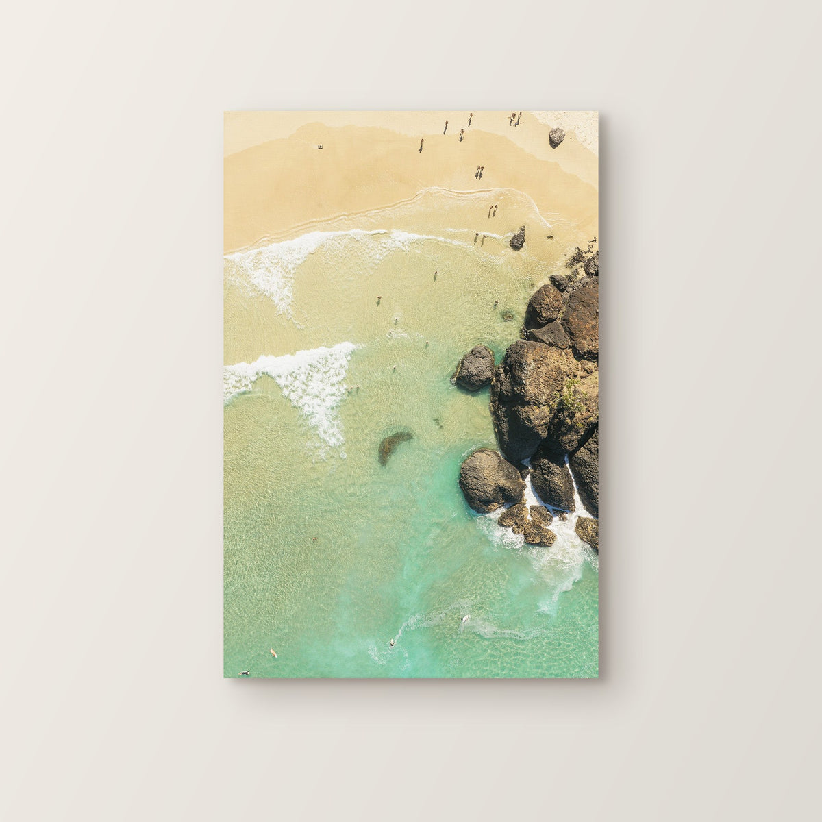 Stretched canvas print of aerial photography of Dreamtime Beach, a rocky shore and golden sand beside turquoise water in portrait orientation on a wall