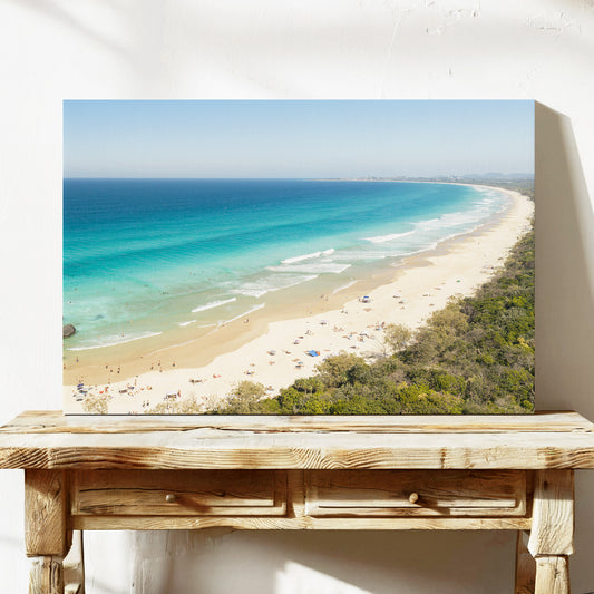 Stretched canvas print of aerial photography of Dreamtime Beach, a long curving beach with turquoise water and coastal bush on a console table