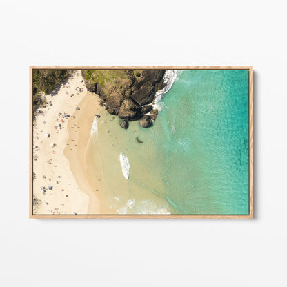 Oak framed canvas print of aerial photography of Dreamtime Beach, headland rocks with sand, turquoise water and a small white boat