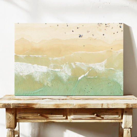 Stretched canvas print of aerial photography of Dreamtime Beach, soft shoreline wash over pale sand with people on the beach on a console table