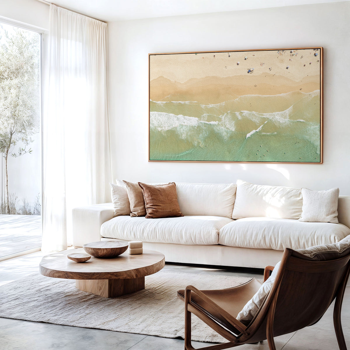 Canvas print of aerial photography of Dreamtime Beach, soft shoreline wash over pale sand with people on the beach hanging above a sofa in a living room