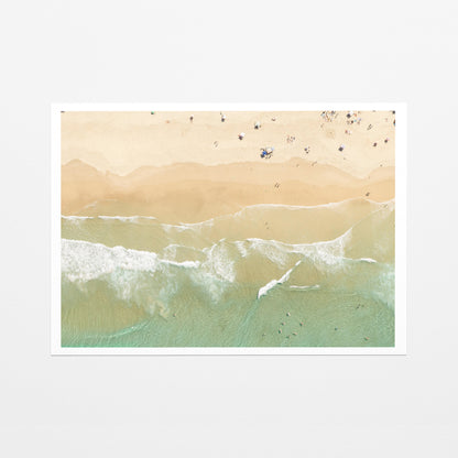 Fine art paper print of aerial photography of Dreamtime Beach, soft shoreline wash over pale sand with people on the beach with a white border