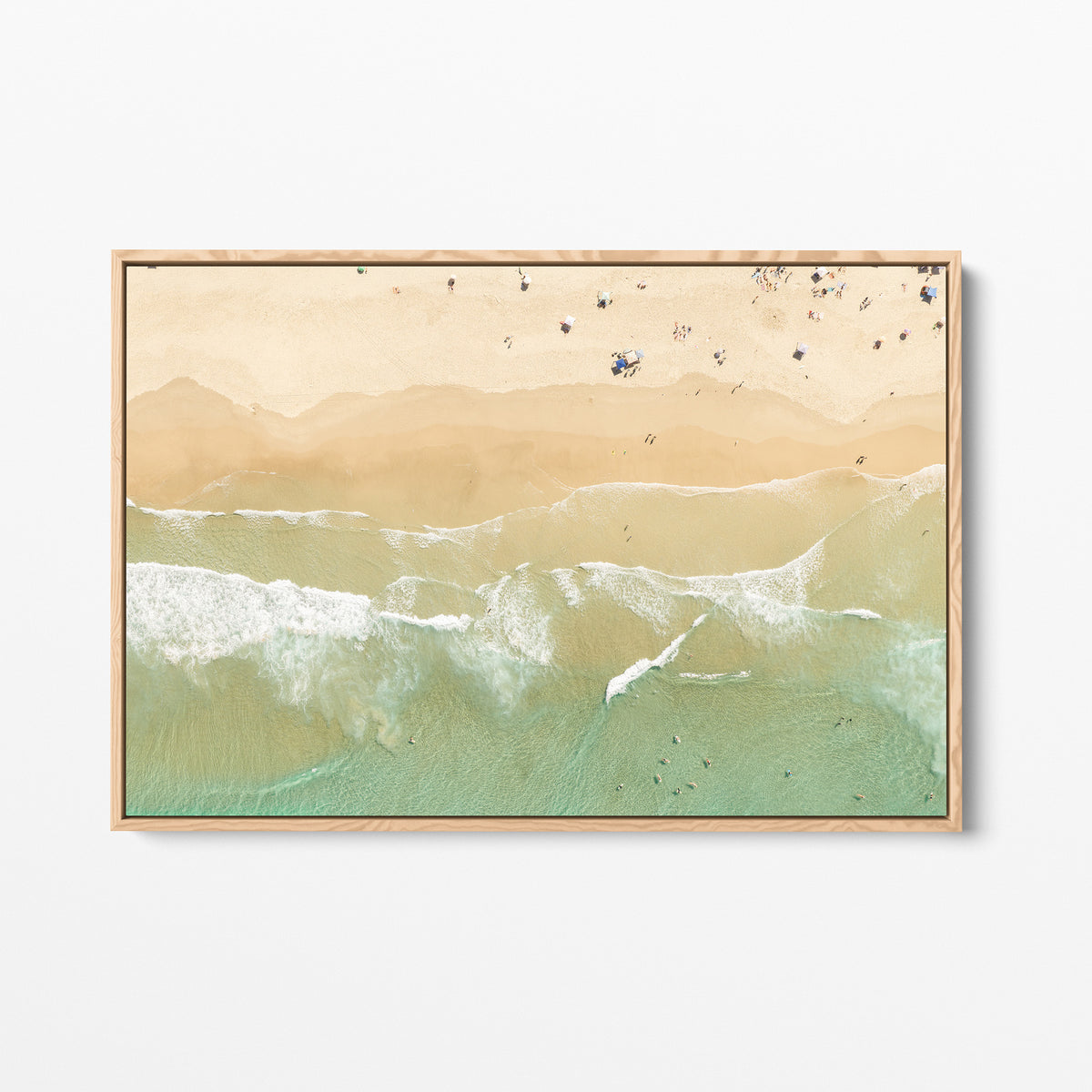 Oak framed canvas print of aerial photography of Dreamtime Beach, soft shoreline wash over pale sand with people on the beach