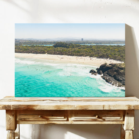 Stretched canvas print of aerial photography of Dreamtime Beach, green coastal bush, a rock outcrop and turquoise water on a console table