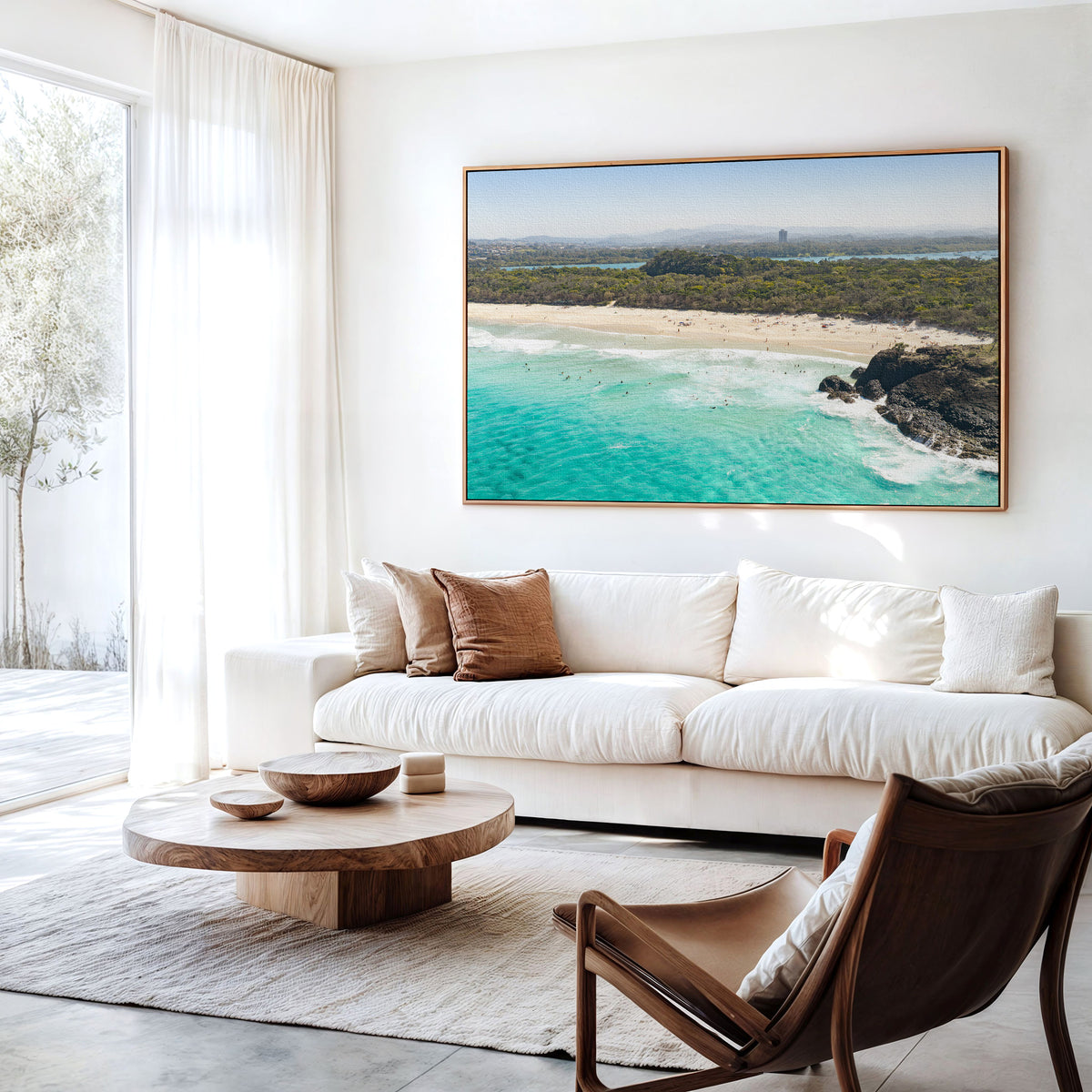 Canvas print of aerial photography of Dreamtime Beach, green coastal bush, a rock outcrop and turquoise water hanging above a sofa in a living room