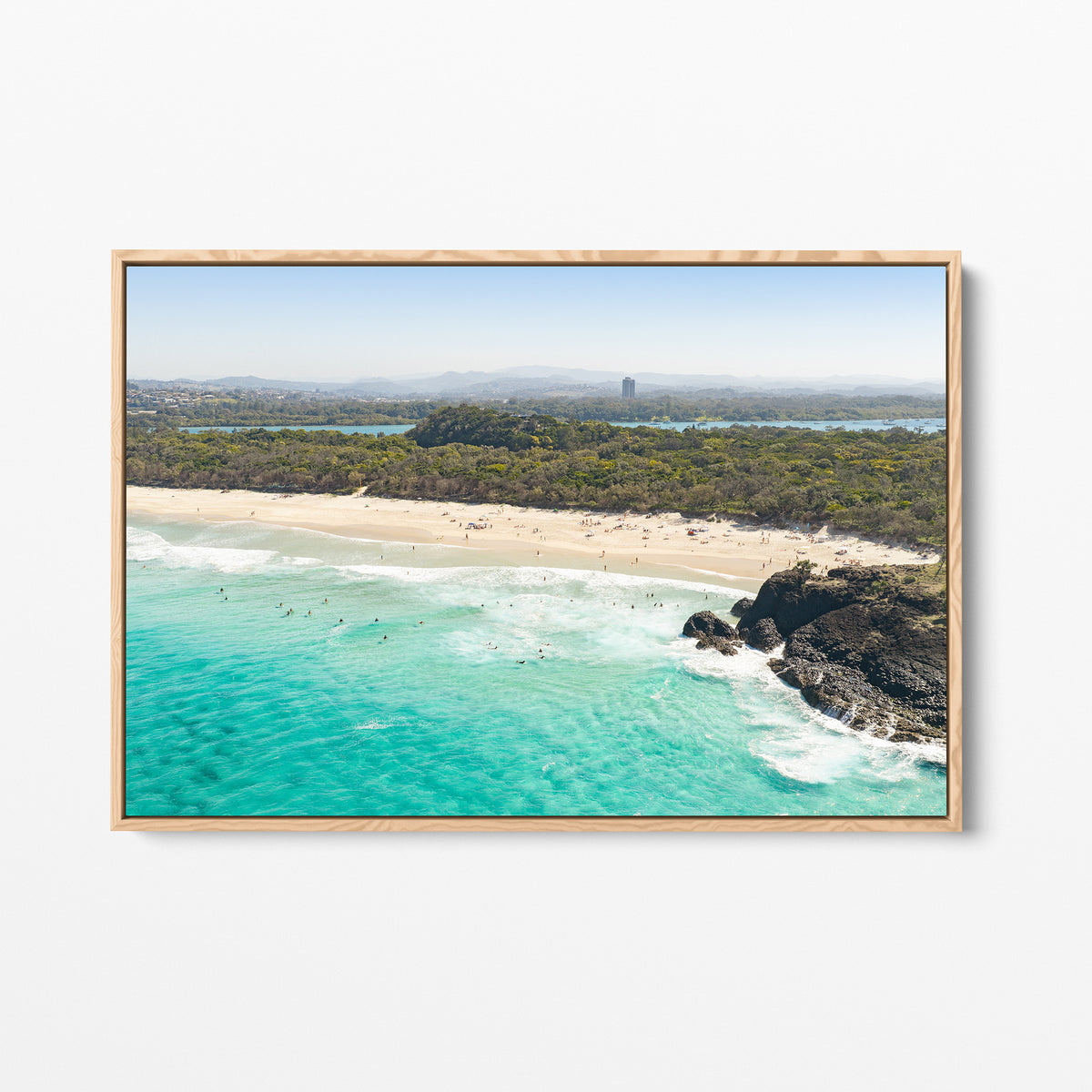 Oak framed canvas print of aerial photography of Dreamtime Beach, green coastal bush, a rock outcrop and turquoise water