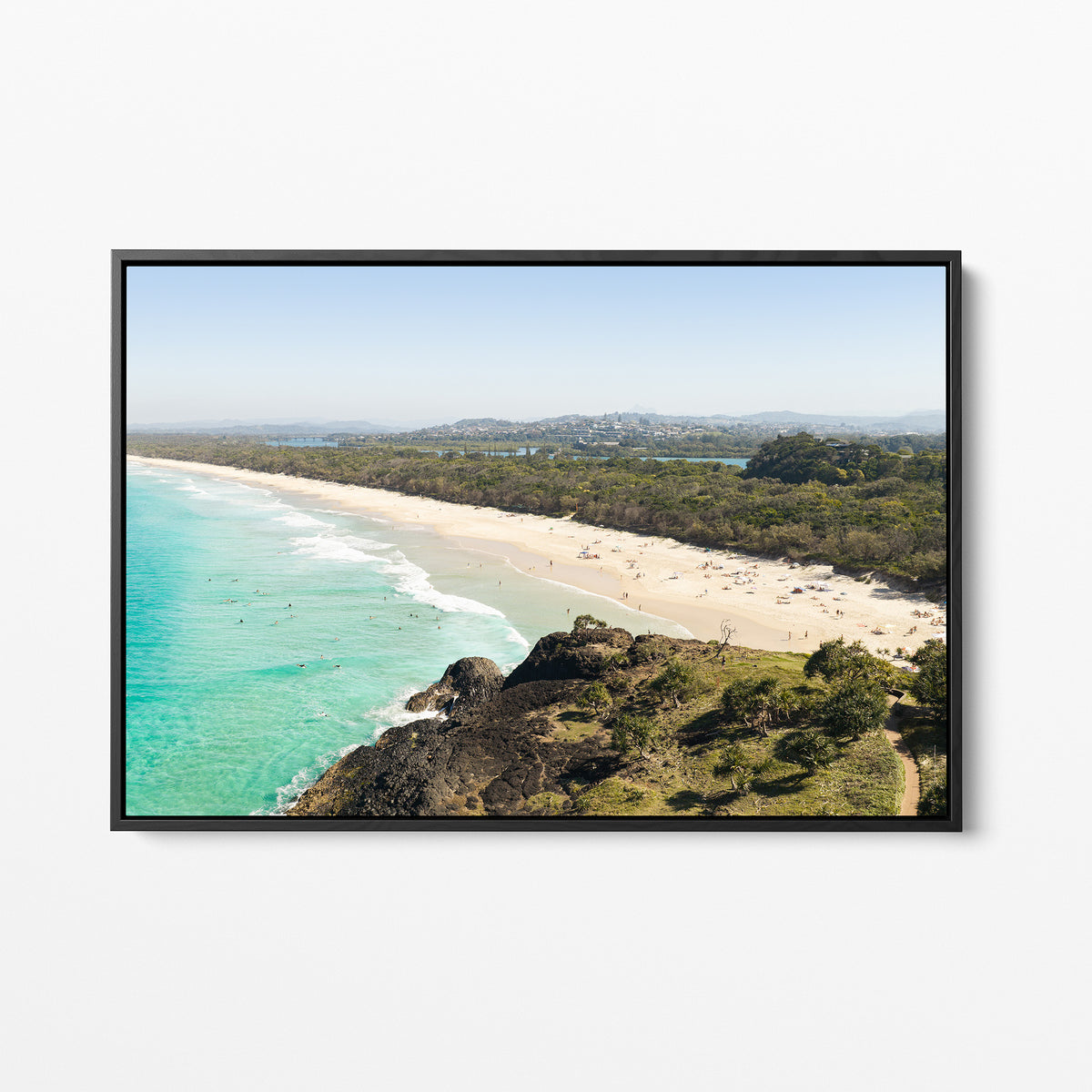 Black framed canvas print of aerial photography of Dreamtime Beach, a bush covered headland above a long beach and turquoise water