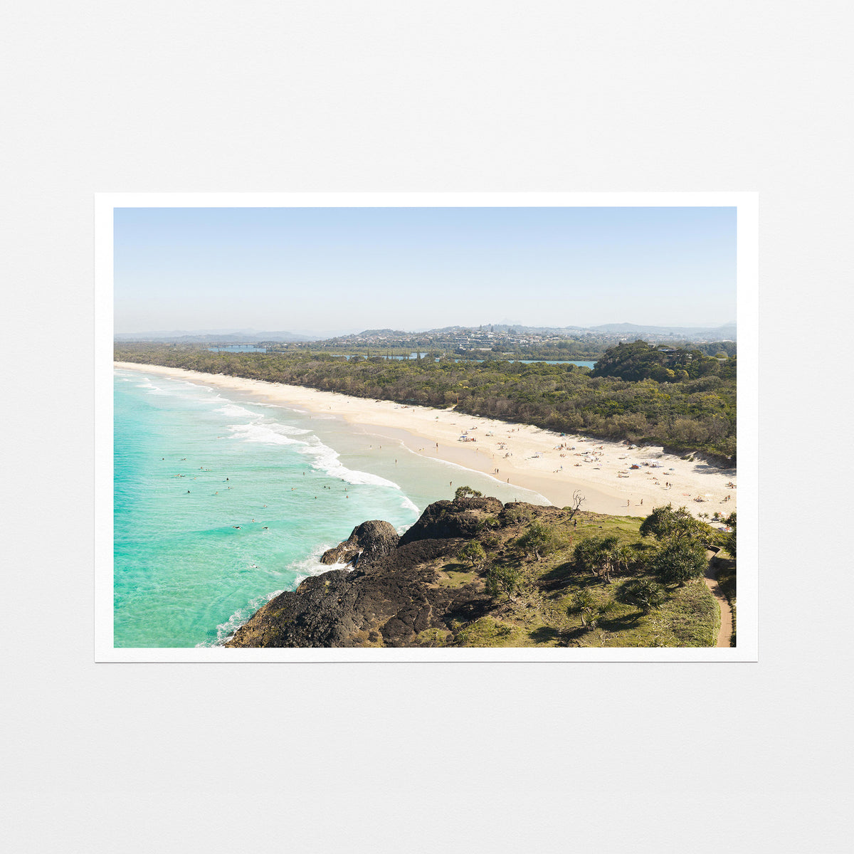 Fine art paper print of aerial photography of Dreamtime Beach, a bush covered headland above a long beach and turquoise water with a white border