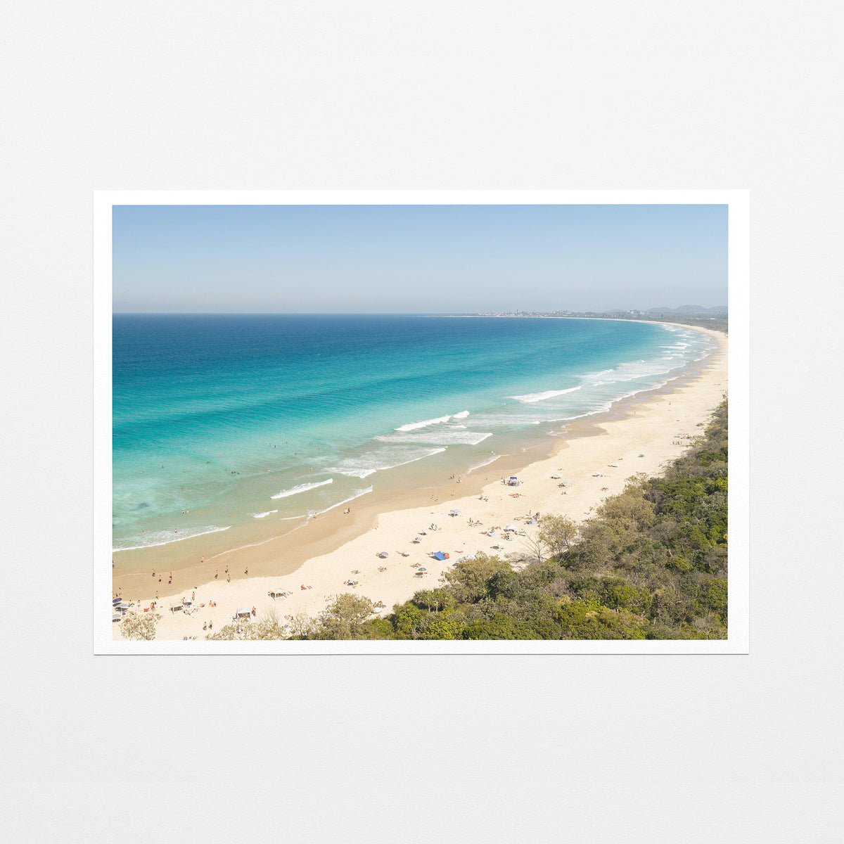 Fine art paper print of aerial photography of Dreamtime Beach, a long curving beach with turquoise water and coastal bush with a white border