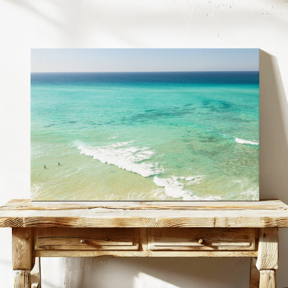 Stretched canvas print of aerial photography of Fingal Head, turquoise water with white wave lines running across the shallows on a console table