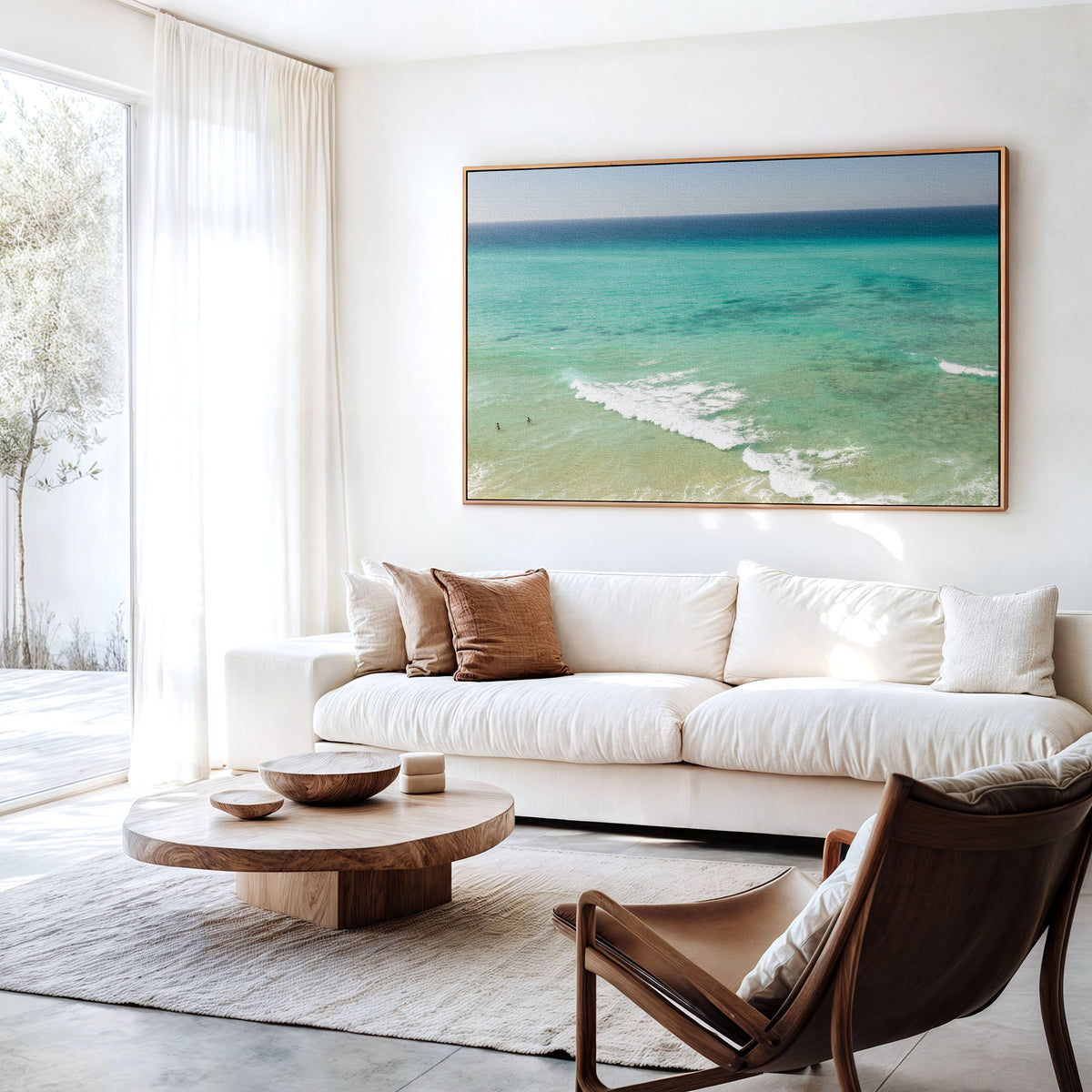 Canvas print of aerial photography of Fingal Head, turquoise water with white wave lines running across the shallows hanging above a sofa in a living room