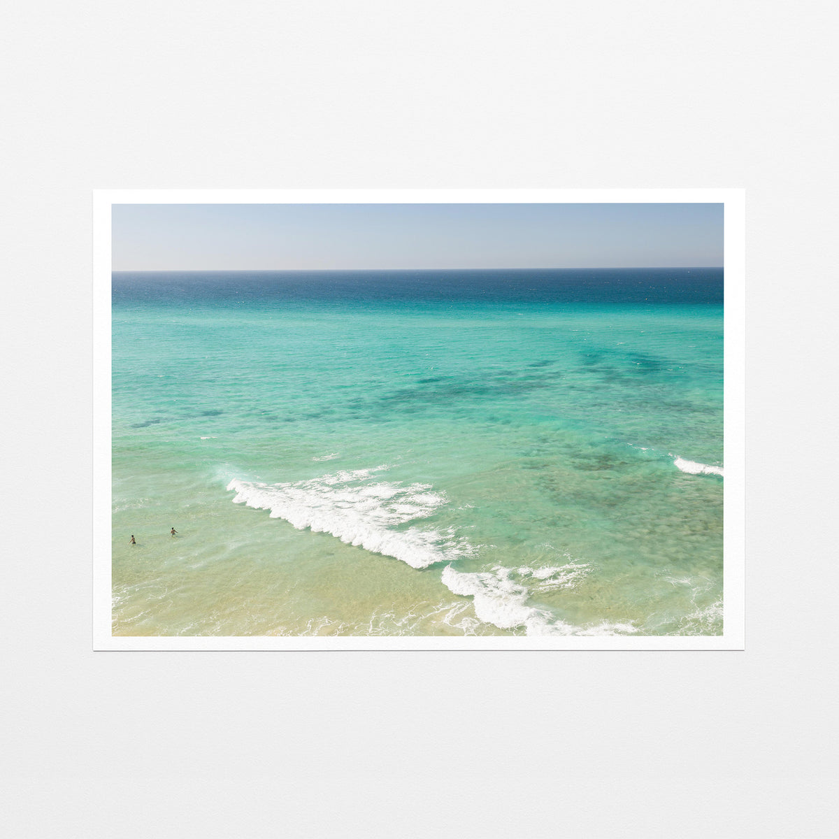 Fine art paper print of aerial photography of Fingal Head, turquoise water with white wave lines running across the shallows with a white border
