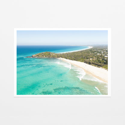 Fine art paper print of aerial photography of Fingal Head, a bush covered headland with houses, a sandy beach and turquoise reef water with a white border