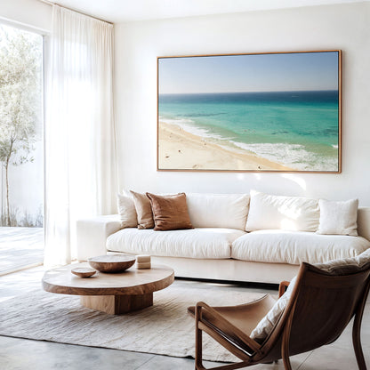 Canvas print of aerial photography of Fingal Head, a long strip of sand with turquoise surf rolling onto the shore hanging above a sofa in a living room
