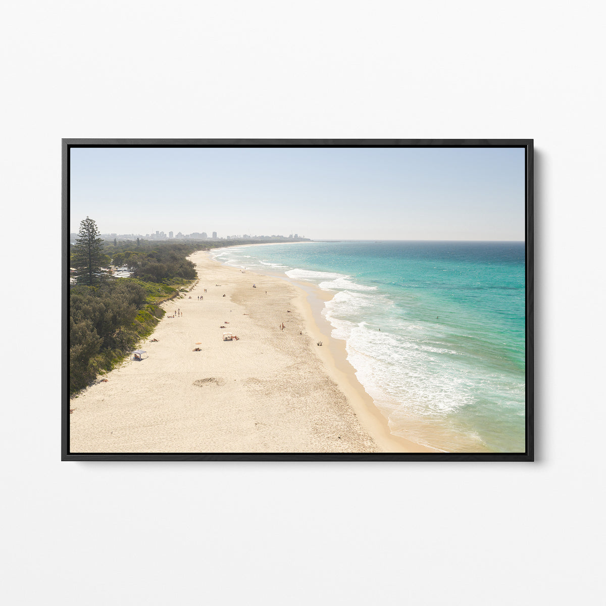 Black framed canvas print of aerial photography of Fingal Head, a long sandy beach with bush on the left and surf rolling onto the shore