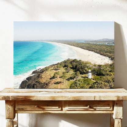 Stretched canvas print of aerial photography of Fingal Head Lighthouse, a white lighthouse on a bush headland above a long beach and turquoise sea on a console table