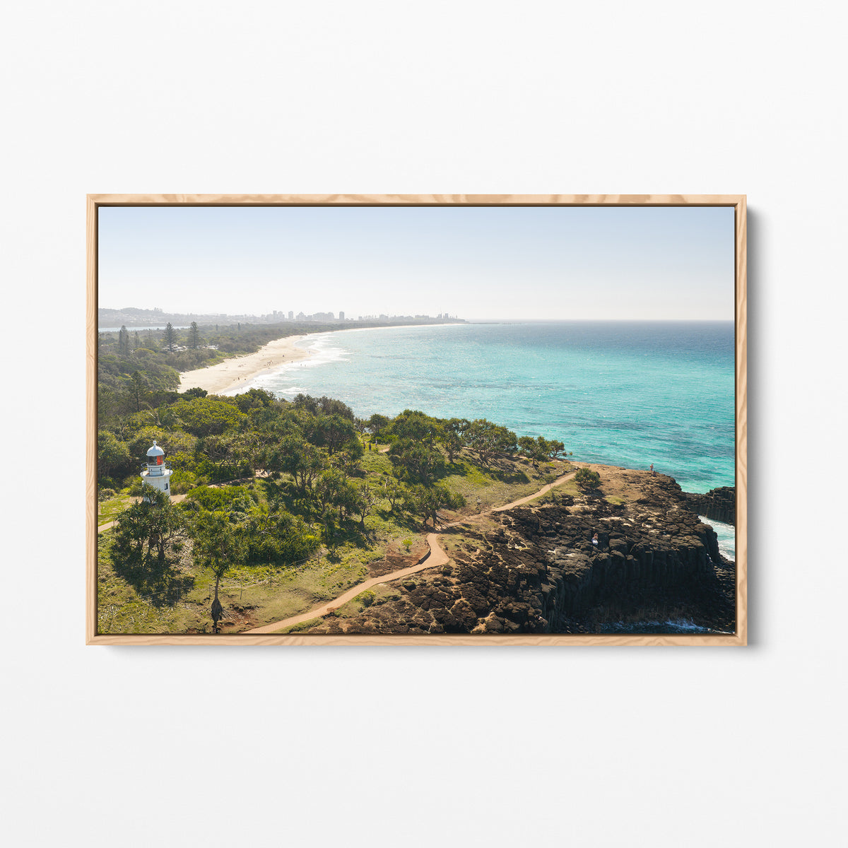 Oak framed canvas print of aerial photography of Fingal Head Lighthouse, bushland with a dirt track, a rocky cliff, the beach and turquoise sea