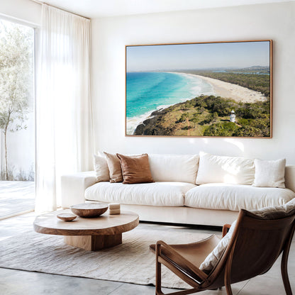 Canvas print of aerial photography of Fingal Head Lighthouse, a white lighthouse on a bush headland above a long beach and turquoise sea hanging above a sofa in a living room