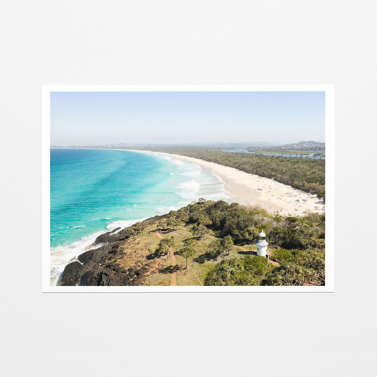 Fine art paper print of aerial photography of Fingal Head Lighthouse, a white lighthouse on a bush headland above a long beach and turquoise sea with a white border