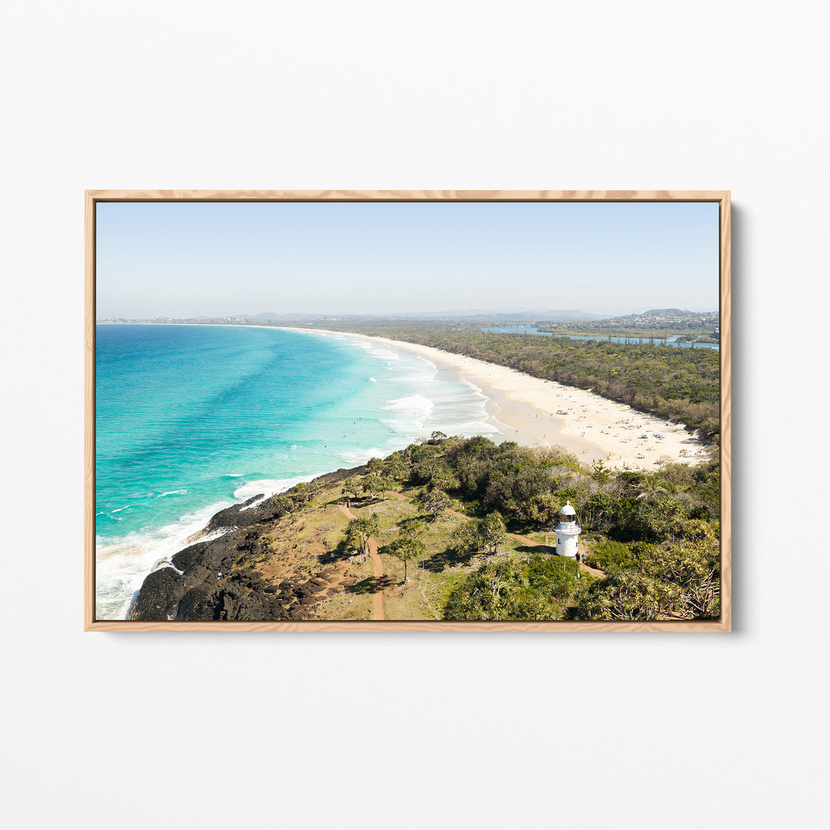 Oak framed canvas print of aerial photography of Fingal Head Lighthouse, a white lighthouse on a bush headland above a long beach and turquoise sea