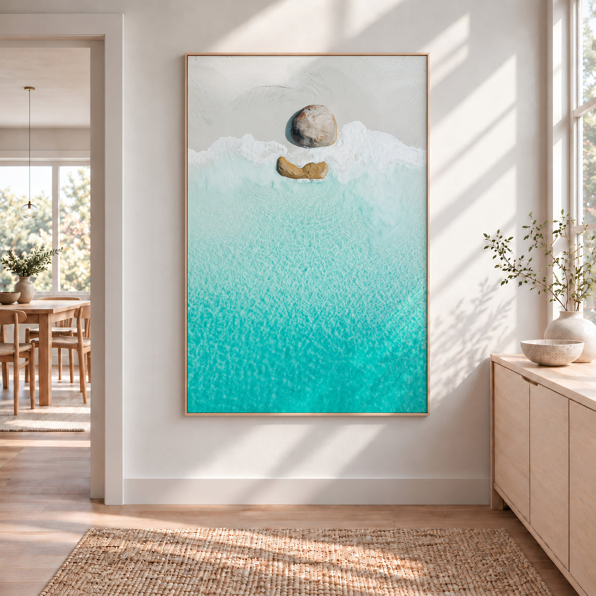Oak framed canvas print of aerial photography of Little Beach, two granite boulders on white sand beside turquoise water in portrait orientation hanging in a hallway