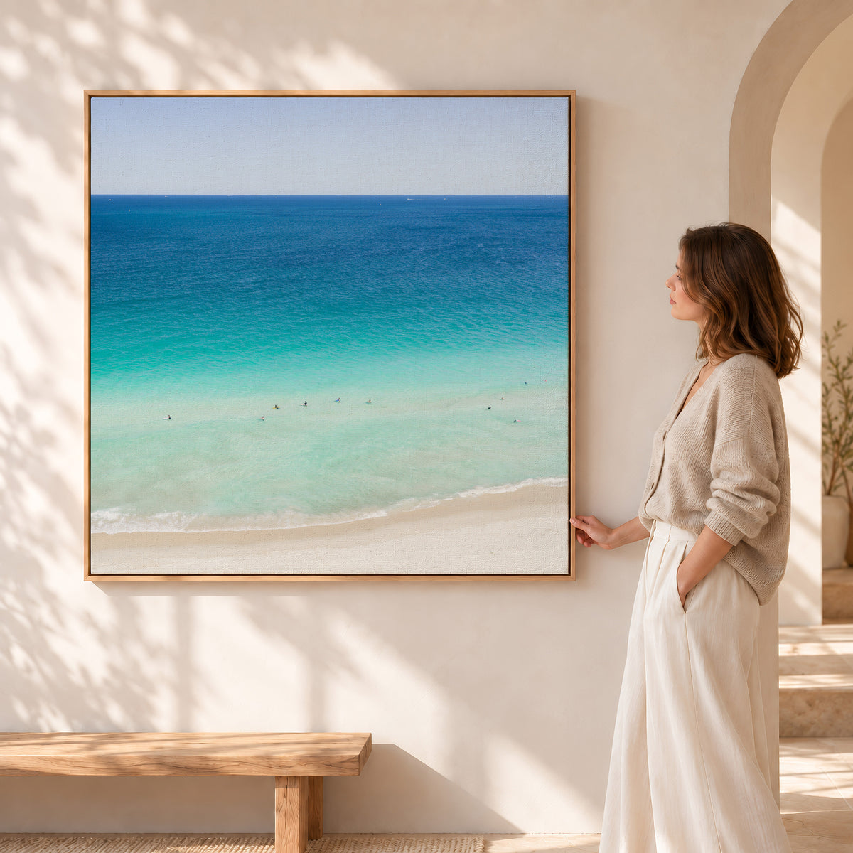 Oak framed square canvas print of aerial photography of Scarborough Beach, swimmers in turquoise shallows beside pale sand, with a woman standing beside it