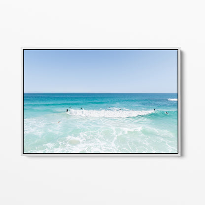 White framed canvas print of aerial photography of Scarborough Beach, a wide view of surfers spread across turquoise water and white foam