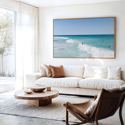 Canvas print of aerial photography of Scarborough Beach, a surfer riding a breaking wave with white foam in turquoise water hanging above a sofa in a living room