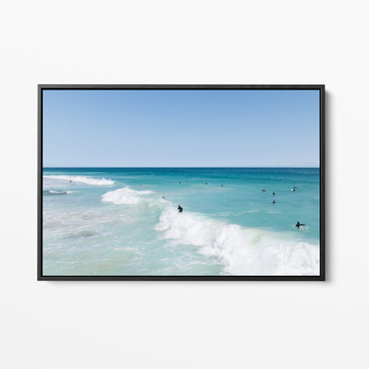 Black framed canvas print of aerial photography of Scarborough Beach, a surfer riding a breaking wave with white foam in turquoise water