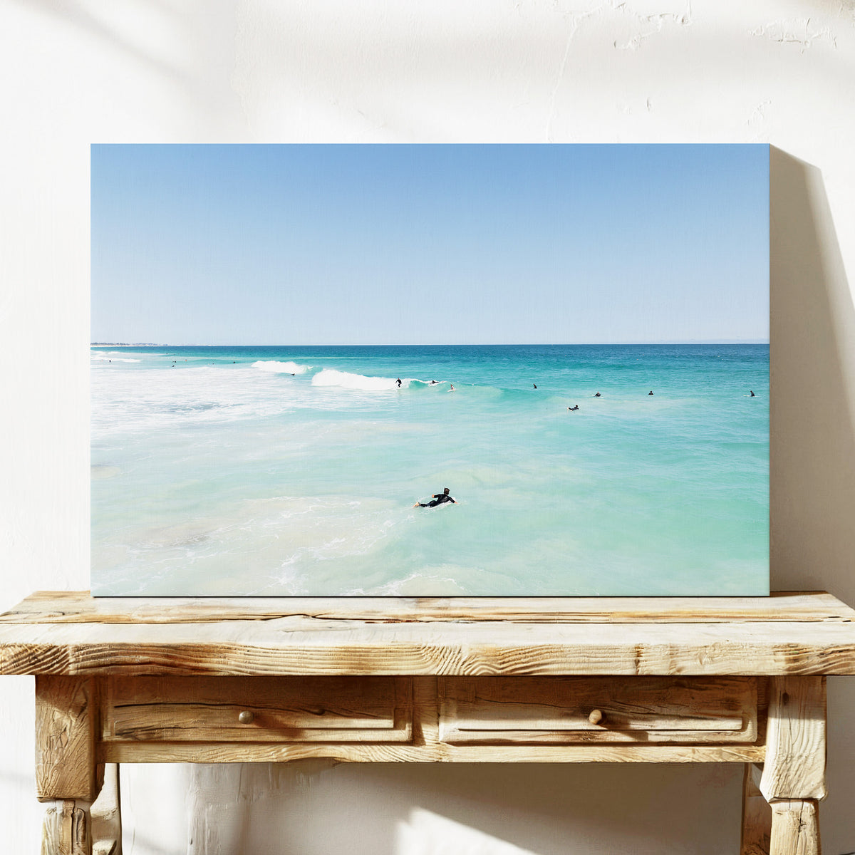 Stretched canvas print of aerial photography of Scarborough Beach, a surfer lying on a board in clear turquoise shallows on a console table