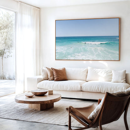 Canvas print of aerial photography of Scarborough Beach, surfers waiting beside a small breaking wave in turquoise water hanging above a sofa in a living room