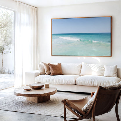 Canvas print of aerial photography of Scarborough Beach, a surfer on a breaking wave in pale turquoise water hanging above a sofa in a living room