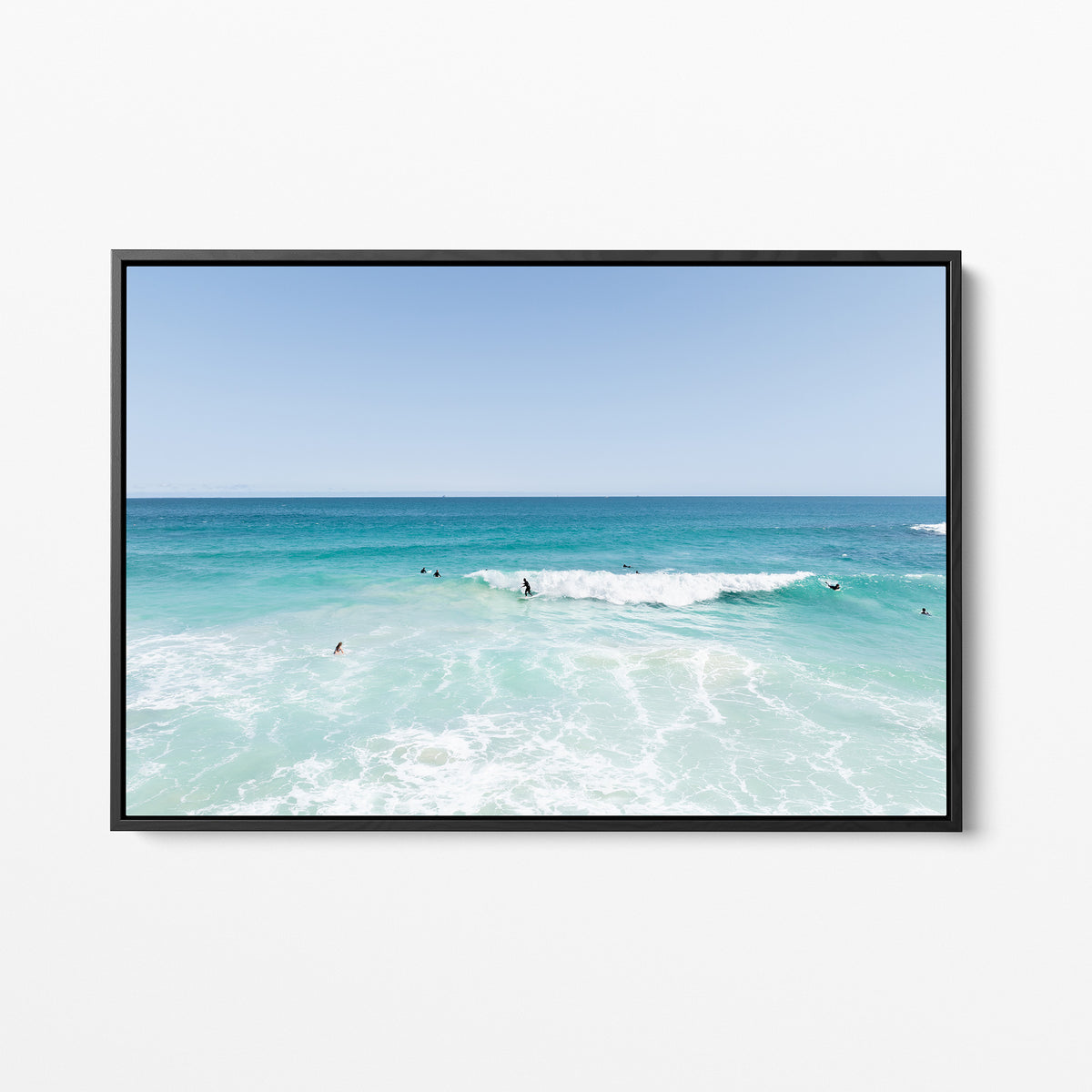 Black framed canvas print of aerial photography of Scarborough Beach, surfers waiting beside a small breaking wave in turquoise water
