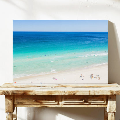 Stretched canvas print of aerial photography of Scarborough Beach, deep blue ocean meeting turquoise shallows and a white sand beach with small figures on a console table