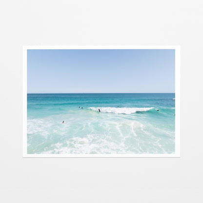 Fine art paper print of aerial photography of Scarborough Beach, surfers waiting beside a small breaking wave in turquoise water with a white border